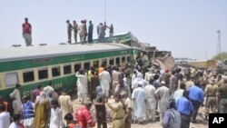 Pejabat dan relawan Pakistan berupaya mengevakuasi korban di lokasi kecelakaan kereta api di Rahim Yar Khan, Pakistan, 11 Juli 2019. 