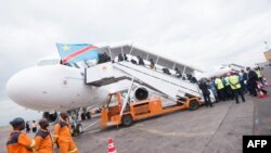 Des passagers embarquent dans un avion à l’aéroport international de N’Djili à Kinshasa, RDC, 9 octobre 2015.