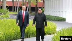 2018년 6월 12일 도널드 트럼프 미국 대통령이 싱가포르 센토사섬 카펠라 호텔에서 김정은 북한 국무위원장과 함께 걷고 있다.