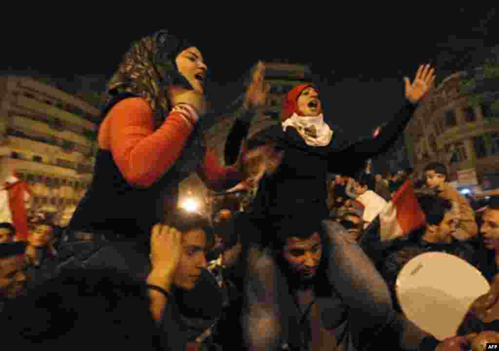 Two Egyptian women celebrate after President Hosni Mubarak resigned and handed power to the military at Tahrir Square, in Cairo, Egypt, Friday, Feb. 11, 2011. Egypt exploded with joy, tears, and relief after pro-democracy protesters brought down President