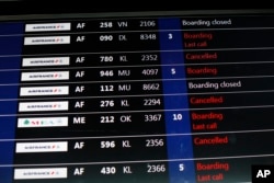 FILE - A passenger information board displays some disruptions at Roissy Charles de Gaulle Airport, in Roissy, north of Paris, Feb. 22, 2018.