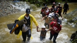 Un grupo de migrantes de Venezuela, Ecuador y Haití cruzan el río Muerto en el Tapón del Darién, mientras continúan su viaje hacia la frontera con Estados Unidos, en Acandí, Colombia el 9 de julio de 2023.