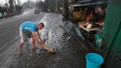 Residents cleans ash fall from Taal Volcano's eruption Monday Jan. 13, 2020, in Tagaytay, Cavite province, south of Manila, Philippines. (AP Photo/Aaron Favila)