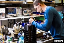 Peneliti, Ethan Jackson, membuat penyetelan purwarupa perangkap nyamuk di laboratorium di Microsoft, dalam foto rilis yang diperoleh Reuters tanggal 30 Juni 2017