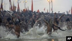 Indian Hindu holy men run naked into the water at Sangam, the confluence of the rivers Ganges, Yamuna and mythical Saraswati, during the royal bath at the start of the Kumbh Mela in Allahabad, India, Janaury 14, 2013.