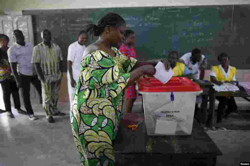 Une femme met son bulletin dans l'urne dans un bureau de vote de Cotonou, pour la présidentielle béninoise, le 6 mars 2016. (REUTERS/Akintunde Akinleye - RTS9I4A)