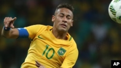 Le Brésilien Neymar, à gauche, dégage une balle de la tête lors d’un match contre le Danemark au stade de Fonte Nova à Salvador, Brésil. 10 août 2016.