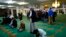 FILE - Men pray as visitors are given a tour of the Birmingham Central Mosque, on visit my mosque day in Birmingham, Feb. 7, 2016. 