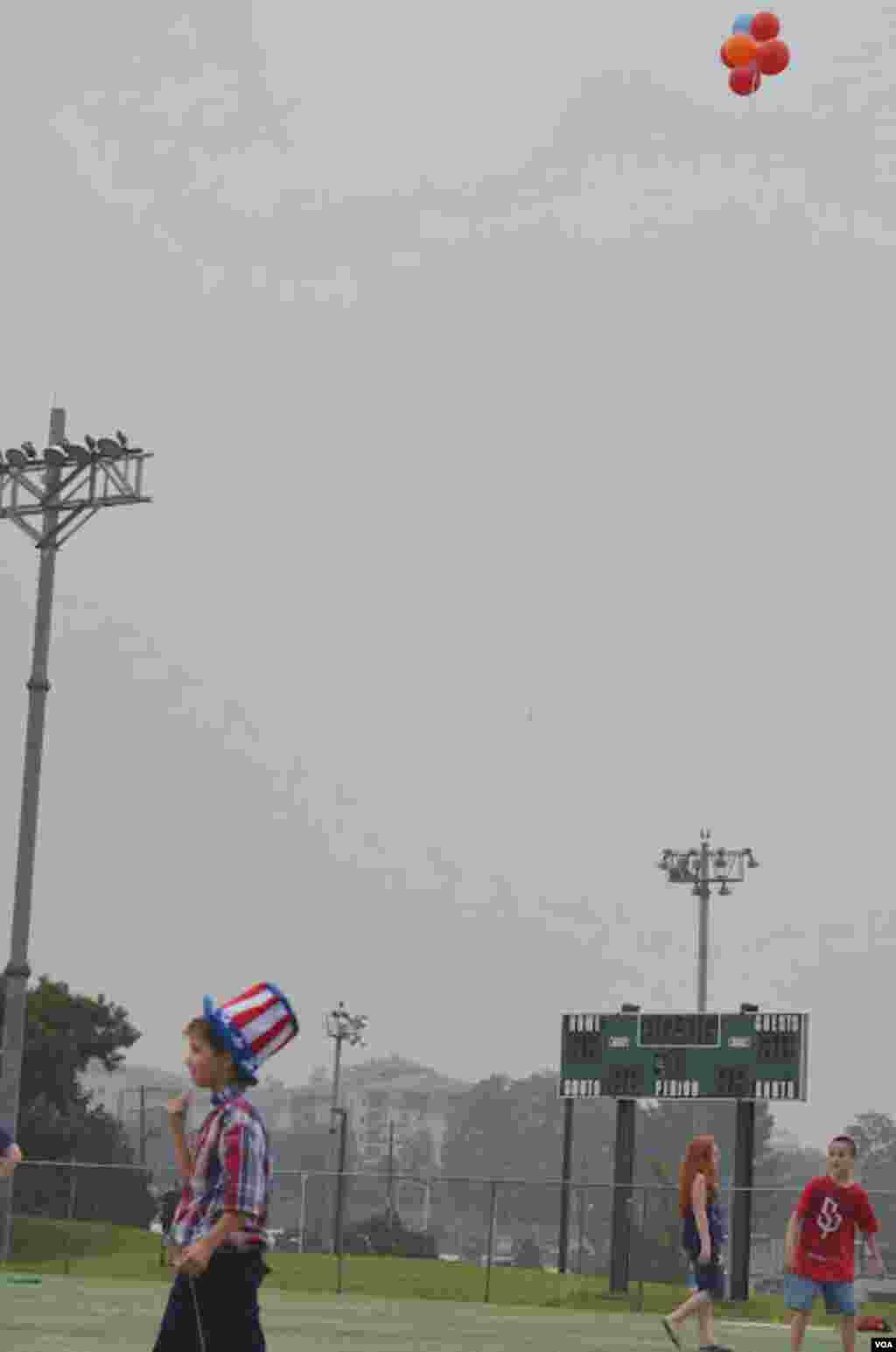 A boy in patriotic wear holds balloons aloft on US Army Garrison Yongsan, South Korea, July 4, 2012. (S.L. Herman/VOA)