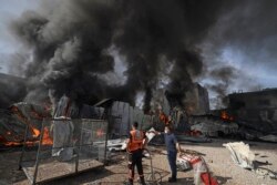Petugas pemadam kebakaran Palestina memadamkan api besar di pabrik kasur Foamco di timur Jabalia di Jalur Gaza utara, pada 17 Mei 2021. (Foto: AFP / Mahmud Hamz)