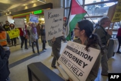 Demonstrators pass a volunteer immigration attorney as they march in support of a ruling by a federal judge in Seattle that grants a nationwide temporary restraining order against the presidential order to ban travel to the United States from seven Muslim countries.