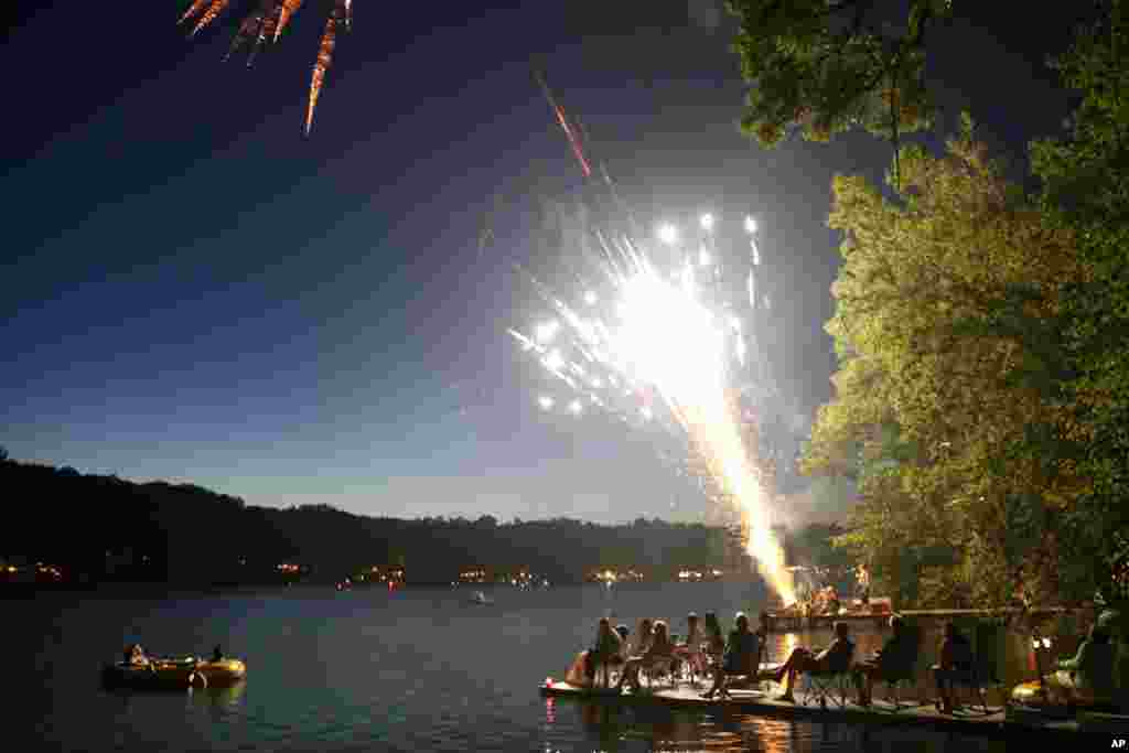 Residents and visitors of Alexander's Lake sit out on their docks and in small boats as they watch neighborhood fireworks as they celebrate Independence Day, July 4, 2013, in Dayville, Connecticut.