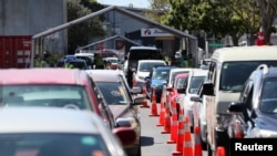 FILE - Members of the public wait in cars at a drive-through coronavirus disease (COVID-19) vaccination clinic during a single-day vaccination drive, in Auckland, New Zealand, Oct. 16, 2021. 
