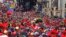 A Venezuelan national flag (L) drapes the coffin of deceased Venezuelan leader Hugo Chavez as it is driven through the streets of Caracas after leaving the military hospital where he died of cancer, March 6, 2013. 