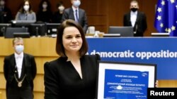FILE - Belarus opposition leader Sviatlana Tsikhanouskaya poses with the Sakharov Prize, the European Union's annual human rights award, during a ceremony at the EU Parliament in Brussels, Dec. 16, 2020.