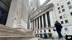 Peatones pasan frente al edificio de La Bolsa de Nueva York en Wall Street, Manhattan, el 20 de agosto de 2024.