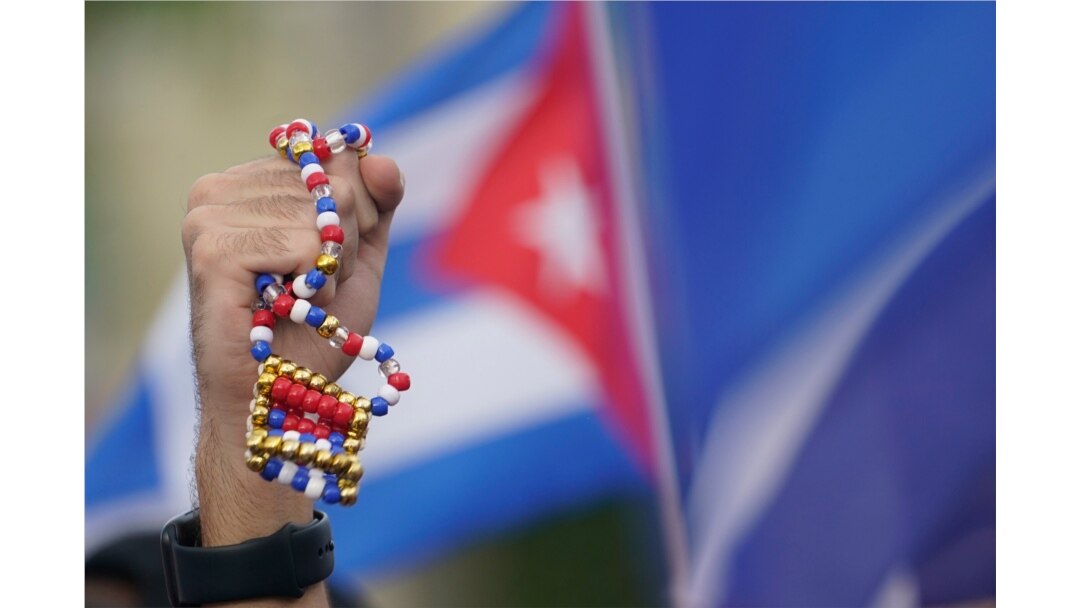 A demonstrator holds up a bead necklace in the colors of the Cuban flag, July 14, 2021, in Miami's Little Havana neighborhood, as people rallied in support of antigovernment demonstrations in Cuba.
