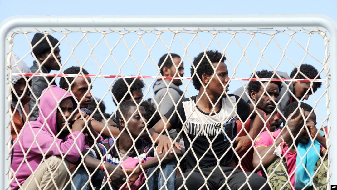 FILE - Migrants wait to disembark from the Italian Navy vessel 'Bettica' in the harbor of Salerno, Italy, May 5, 2015.