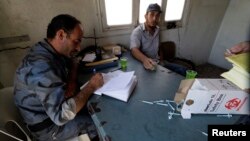 A member of the Free Revolutionary Police carries out an inspection on a measles vaccine in the southern Idlib, Sept. 17, 2014.