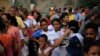 Migrantes de varios países latinoamericanos hacen fila para recibir alimentos de voluntarios estadounidenses al pie del puente que cruza a Brownsville, Texas, en Matamoros, México. Cientos esperan por meses en fila para solicitar asilo en EE.UU. Foto de junio 26 de 2019.