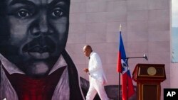 FILE - In this Oct. 17, 2015 file photo, Haiti's President Michel Martelly returns to his seat after delivering a speech during a ceremony marking the 209th anniversary of the assassination of independence hero Gen. Jean-Jacques Dessalines, in Port-au-Pri