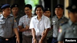 FILE - Police escort detained Reuters journalists Kyaw Soe Oo and Wa Lone as they arrive before a court hearing in Yangon, Myanmar, Aug. 20, 2018.