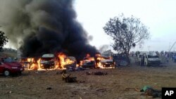 Victims of a blast lie on the ground as fire and smoke rise at a bus park in Abuja, Nigeria. April 14, 2014.