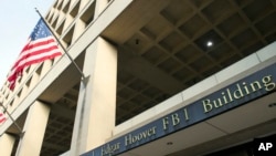 FILE - The FBI's J. Edgar Hoover Headquarters is seen across the street from the Justice Department in Washington, Nov. 2, 2016. 