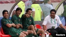 Portugal's Luis Figo (2nd R) gestures as he talks with former soccer star Eusebio (R) and team mates Deco (L) and Paulo Ferreira during the World Cup soccer training session in Stuttgart stadium, July 7, 2006. 