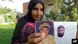 The mother of former Guantanamo detainee Obiadullah holds pictures of her son, in Haiderkhil, Khost province, Afghanistan, Aug. 16, 2016. The case files of Afghan detainees at Guantanamo were "full of mistakes," a researcher with the Afghanistan Analysts Network says.