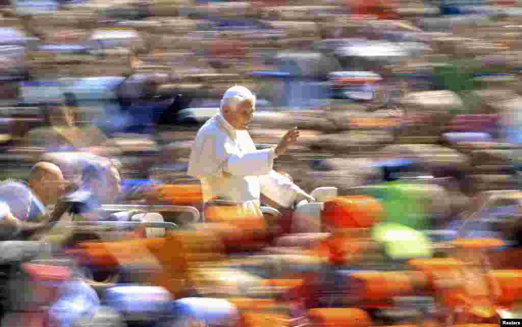 Pope Benedict waves as he arrives to lead the weekly general audience in St. Peter&#39;s Square at the Vatican, April 18, 2012. 