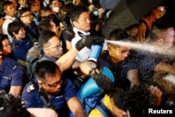 Police use pepper spray as they clash with pro-democracy protesters at an area near the government headquarters building in Hong Kong early October 16, 2014.