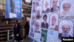 Women walk past electoral posters for the upcoming elections in central Tehran, Iran, Feb. 24, 2016.