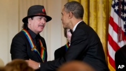 El presidente Barack Obama felicita a Carlos Santana por haber recibido el premio del Kennedy Center.