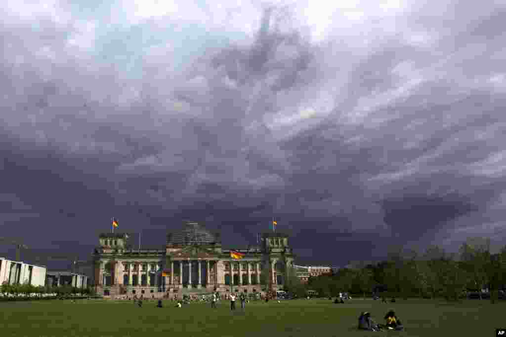Dark clouds hang over the Reichstag, the German parliament Bundestag building, in Berlin.