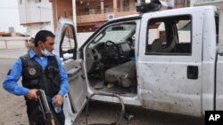 Polisi Irak memeriksa lokasi ledakan bom bunuh diri di sebuah TPS di Kirkuk, 290 kilometers utara Baghdad (28/4).