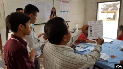 ក្រុម​មន្ត្រី​រៀបចំ​ការ​បោះឆ្នោត បាន​ប្រមូល និង​រាប់​សន្លឹក​ឆ្នោត នៅ​ការិយាល័យ​បោះឆ្នោតក្នុង​សាលា​បឋមសិក្សា​ស្លាកែត នៅ​ថ្ងៃ​ទី៤ ខែ​មិថុនា ឆ្នាំ២០១៧។ (អ៊ិត សូធឿត/VOA)