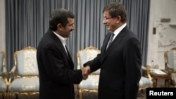 Turkey's Foreign Minister Ahmet Davutoglu (R) shakes hands with Iranian President Mahmoud Ahmadinejad before an official meeting in Tehran, January 5, 2012. 