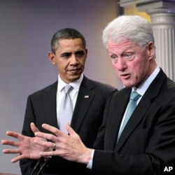 President Barack Obama looks on as former President Bill Clinton speaks in the briefing room of the White House in Washington, 10 Dec 2010