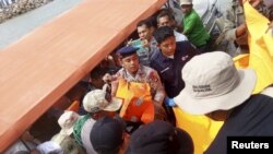 Tim SAR dan warga setempat membantu mengangkat korban kapal feri yang tenggelam di Sulawesi.