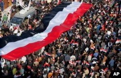 Followers of Iraq's influential Shiite cleric Muqtada al-Sadr chant slogans as they wave national flags during a demonstration against corruption in Baghdad, Iraq, Feb. 11, 2017.