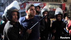 Polisi anti huru-hara menangkap seorang demonstrate di pusat kota Kairo (26/11).