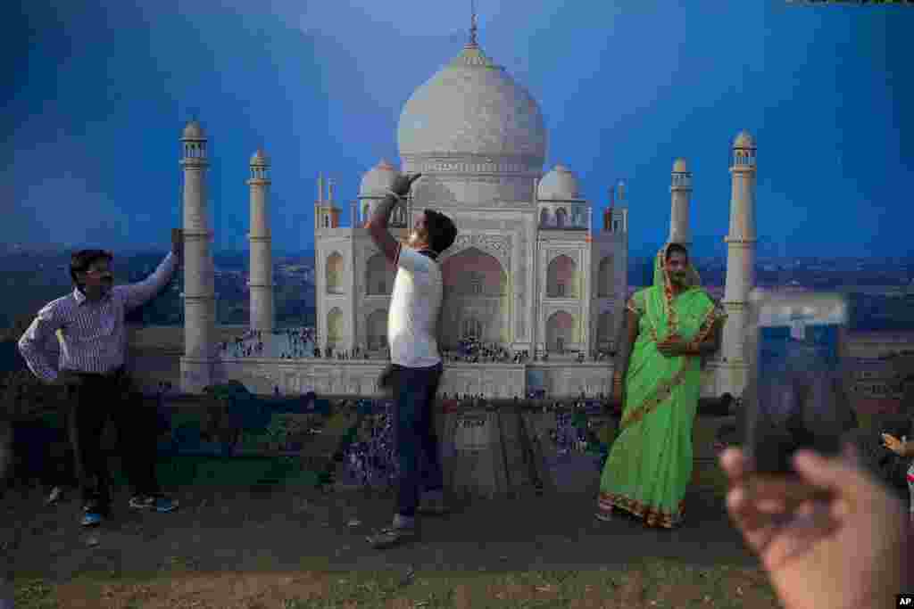 Indians are photographed infront of a photo of Taj Mahal at a food and culture festival near the India Gate war memorial as part of Independence Day celebrations in New Delhi.