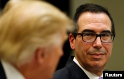 FILE - U.S. Treasury Secretary Steve Mnuchin listens to President Donald Trump speak during a "strategic initiatives" lunch at the White House in Washington, Feb. 22, 2017.