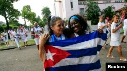 FILE - Recently released dissidents Haydee Gallardo (L) and Sonia Garro hold the Cuban national flag during a march in Havana, Jan. 11, 2015. 
