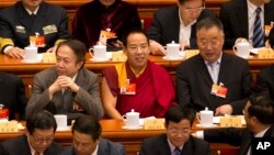 FILE - Gyaltsen Norbu, the Chinese government-appointed 11th Panchen Lama, center, sits with fellow delegates before the closing ceremony of the Chinese People's Political Consultative Conference (CPPCC) at the Great Hall of the People in Beijing, March 13, 2015.
