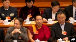 FILE - Gyaltsen Norbu, the Chinese government-appointed 11th Panchen Lama, center, sits with fellow delegates before the closing ceremony of the Chinese People's Political Consultative Conference (CPPCC) at the Great Hall of the People in Beijing, March 13, 2015.