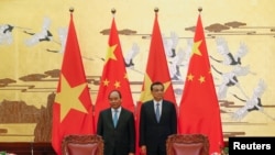 FILE - Chinese Premier Li Keqiang with Vietnamese Prime Minister Nguyen Xuan Phuc (L) attend a signing ceremony at the Great Hall of the People in Beijing, China.