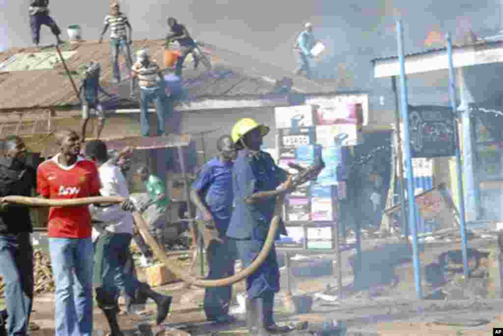 Men struggle to put out the flames as a fire engulfs an auto parts market in Kaduna, Nigeria on Wednesday, Dec. 7, 2011. Emergency officials say at least seven people died in the explosion Wednesday morning in the central Nigerian city that straddles the 