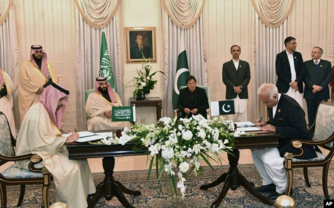 Saudi Arabia's Crown Prince Mohammed bin Salman, center left, and Pakistani Prime Minister Imran Khan, center right, witness the signing ceremony of the Memorandum of Understanding (MOU) on Petroleum, in Islamabad, Pakistan, Feb. 17, 2019.